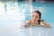 Asian woman in swimsuit smiling in swimming pool, active summer vacation concept