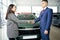 Asian woman takes car keys from man in business suit