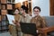 Asian woman teacher in civil servant uniform smiling looks at the camera holding a laptop computer