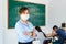 Asian woman teacher wearing masks to prevent the outbreak of Covid 19 in classroom with student while back to school reopen their