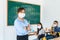 Asian woman teacher wearing masks to prevent the outbreak of Covid 19 in classroom with student while back to school reopen their
