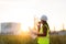 Asian woman technician Industrial engineer using walkie-talkie and holding bluprint working in oil refinery for building site