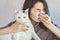 Asian woman with tissue sneezing has allergy to a cat