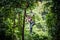 Asian woman TOURIST adult wearing casual clothes Zip Line On Focus FOREST TR