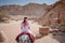 Asian woman tourist riding donkey in Petra, Jordan