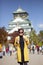 Asian woman tourist taking a photograph at osaka castle one of most popular traveling destination in japan