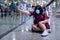 Asian woman tourist wearing a surgical masks Sitting on the floor of a train station walkway