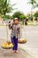 Asian woman trader carrying Rambutan mango banana and mandarin