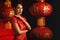 Asian woman in tradional chinese red costume with background of chinese lantern for chinese new year celebration