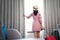 Asian woman traveller in pink dress arrive to room in hotel and open curtain