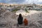 An Asian woman traveller sitting on top of Roman theater ruin and ancient Roman building in Amman capital city of Jordan