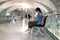 Asian woman traveller using smart phone, waiting for boarding at the airport\'s terminal