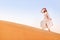 Asian woman in turban travels in Sahara desert. Adventure and life experience concept
