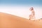 Asian woman in turban travels in Sahara desert. Adventure and life experience concept