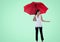 Asian woman with umbrella holding an invisible object against copy space on green background