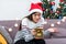 Asian woman upset when open gold xmas gift box at holiday party on sofa,boredom Christmas party present
