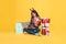Asian woman using computer for shopping gift box online isolated on yellow background. cyber monday and christmas new year concept