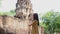 Asian woman using mobile smart phone taking photo of ancient ruin in Thailand and upload to social media network.