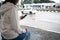 Asian woman is using on smartphone, checking social media network  while waiting taxi at bus stop in rainy day