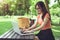 Asian woman using and typing on laptop keyboard in outdoors park. Woman chatting to her friends on social network. People and