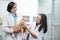 Asian woman vet holding and examining a cat brought by a male veterinarian