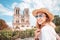 Asian woman visiting famous Notre Dame Cathedral after the Fire. Europe travel and sightseeing tours concept