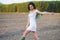 Asian woman, walking in the countryside, wearing a white dress and green wellies.