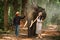 Asian woman walking with elephant and mahout in the forest. Tourism asian women holding camera in elephant village