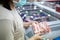 Asian woman wear face mask,choosing frozen pork food in freezer at supermarket,people panic buying and hoarding during the Covid-