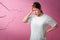 Asian woman wear white t-shirt feelling sick have headache with migraine headaches on cracks pink background, With clipping path