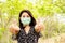 Asian woman wearing face mask outdoors to prevent virus covid-19  with thump up hand