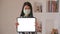 Asian woman wearing a mask holding a tablet facing the front screen for a message to protect against Corona virus or Covid-19