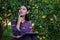 Asian woman wearing plaid shirt sitting thinking of a marketing plan in her tangerine orchard