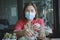 Asian woman wearing protection mask planting cactus at home