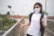 Asian woman wearing protective face mask scared disgusted walking on overcrossing city street. New lifestyle with Corona Virus