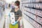 Asian woman wearing protective mask and holding toilet paper during shopping in supermarket or grocery, protect coronavirus