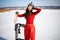 Asian Woman Wearing A Snowboard Mask And Tracksuit Rests With Snowboarding