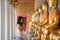 Asian woman in a white t-shirt to pay respect to Buddha statue in the Buddhist temple while traveling in Thailand