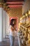 Asian woman in a white t-shirt to pay respect to Buddha statue in the Buddhist temple while traveling in Thailand