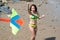 Asian women in bikini are playing colorful kite for fun on the beach.