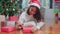 Asian women celebrate Christmas festival. Female teen wear sweater and santa hat relax happy write a wish on gift near Christmas