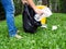 Asian women collect garbage in black bags, With yellow trash placed in garden.