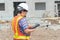 Asian women engineering holds a tablet for use in the inspection of construction sites for accuracy and in accordance with the pla