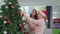 Asian women friends decorate Christmas tree at Christmas festival. Female teen happy smiling celebrate xmas winter holidays