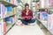 Asian women in library reading something in a book and choosing a book in a library.