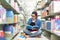 Asian women in library reading something in a book and choosing a book in a library.