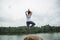 Asian women relax in the holiday. Play if yoga. On the rocks in the middle of the water