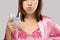 Asian women in satin nightwear and pink robe rinsing and gargling while using mouthwash