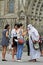 Asian women show photos to a street artist on a smartphone on the streets of Barcelona