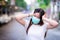 Asian women showed signs of frustration as new virus spread and it affected economy. Woman wearing a green medical face mask.
